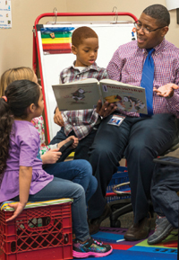 Lavanta Williams reading to young students Emily Alvarado, Bailey Frazier and Jaden Cowans.