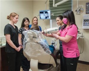 Dental assistants in training Kimberlee Ryder, Maribel Martinez, Karissa Siwa and Jenna Mata look on as Sherri Napoleon demonstrates how to take an X-ray with Amanda Cortez. Photo by Nesossi Studios.