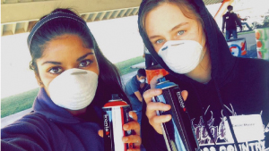 YIP participants Shreya Desai and Cassie Moore volunteering by painting in the community.